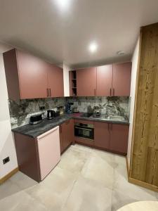 Una cocina vacía con gabinetes marrones y un fregadero. en Domaine Nature Cottage Vosges Spa, en Anould
