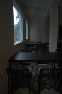an empty room with tables and chairs and a window at Traveller's Hostel by Spirit of Adventure, Dirang in Dirang Dzong