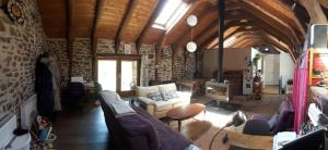 a living room with a couch and a tv at B&B Bio et écolo du Besset in Yssingeaux