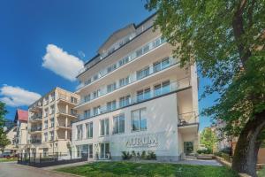 an apartment building with an autumn sign on it at Aurum Aparthotel - Nowe Apartamenty blisko Plaży - Neue Appartements in Strandnähe in Świnoujście
