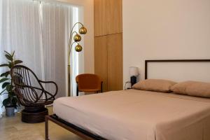 a bedroom with a bed and a chair and a window at Redimeti Country House in Avola +79 photos