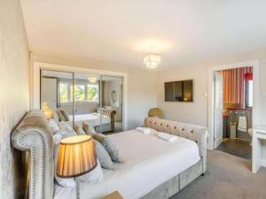 a large bedroom with a bed and a couch at 5 Bed House -Sleeps 10- Hot Tub - Garden - Parking in Edinburgh +19 photos