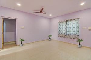 a living room with two potted plants in it at Hotel O Liberty Service Apartment in Dhantoli