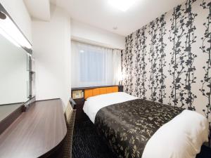a hotel room with a bed and a window at APA Hotel Ueno Hirokoji in Tokyo