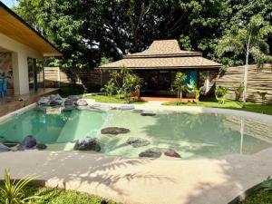a large pool of water with rocks in a yard at Turquoise Villa in Floridablanca