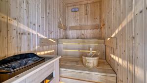 a wooden sauna with a tub and a bucket at Slowmood - domy z sauną i jacuzzi, Sun & Snow in Podgórzyn