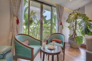 a living room with two chairs and a table at Tranquil 3 BHK Pet-Friendly Gateway with Bathtub, Balcony and Scenic Views in Lonavala