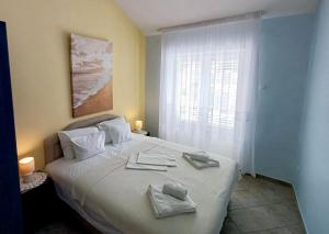 a bedroom with a bed with two towels on it at Apartments Mitrovići Miločer in Sveti Stefan