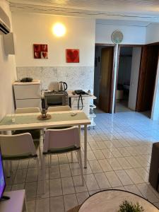 a kitchen with a table and chairs in a room at Apartman MAR in Mandre