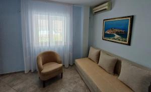 a living room with a couch and a chair at Apartments Mitrovići Miločer in Sveti Stefan