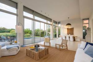 a living room with white furniture and large windows at Beach House Galei in Herzliya B