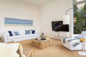 a living room with a couch and a tv at Beach House Galei in Herzliya B
