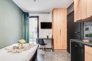 a room with a bed and a table with flowers on it at Muzealna Business Rooms in Opole