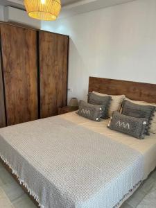 a bedroom with a large bed with a wooden headboard at Luxury 2 bedrooms apartment in kantaoui in Bin Rhilouf