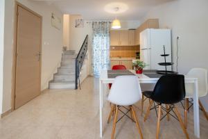 a kitchen and dining room with a table and chairs at Sofia Maisonette by RentalsPro - Sani Halkidiki in Sani Beach