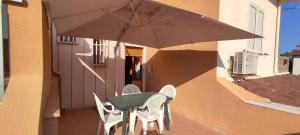 a table and chairs and an umbrella on a balcony at Posidonia Guest House La Caletta Sardegna in La Caletta