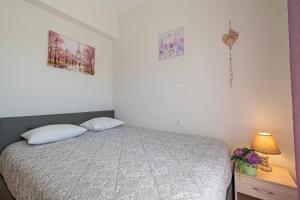 a bedroom with a bed and two pictures on the wall at Sofia Maisonette by RentalsPro - Sani Halkidiki in Sani Beach