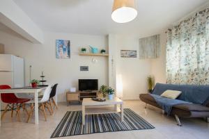 a living room with a couch and a table at Sofia Maisonette by RentalsPro - Sani Halkidiki in Sani Beach