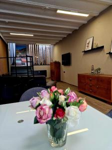 a vase filled with pink and white flowers on a table at Altstadt Quartier Hallenberg - Modernes Ferienappartment in Hallenberg