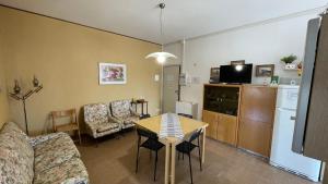 a living room with a couch and a table with chairs at Cleo Girasole in Porto Recanati