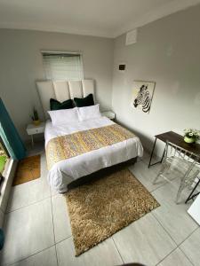 Un dormitorio con una cama grande y una mesa. en Privacy and comfort, en Durban