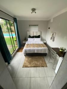 Un dormitorio con una cama y una ventana grande. en Privacy and comfort, en Durban