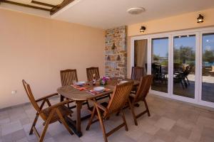 a dining room with a wooden table and chairs at Syros Sun Beach Villa in Vari