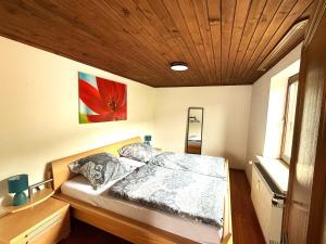 a bed in a room with a wooden ceiling at Ferienwohnung Bayerischer Wald in Zwiesel