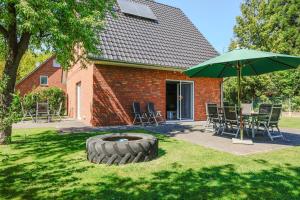 a patio with an umbrella and a table and chairs at Ferienhaus Hünzingen in Walsrode
