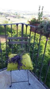 a chair sitting on a balcony with plants on it at Monferrato vini castelli in CastellʼAlfero