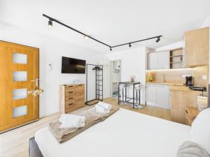 a kitchen and living room with white walls and wooden cabinets at Apartmani Jesenova in Selce