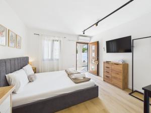 a bedroom with a large bed and a flat screen tv at Apartmani Jesenova in Selce