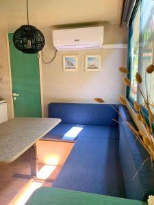 a room with a blue couch and a table at Comfortabele familie chalets met veranda incl airco dichtbij zee! in Viareggio
