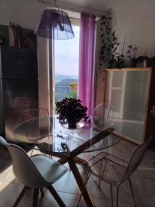 a glass table and chairs in a room with a window at Monferrato vini castelli in CastellʼAlfero