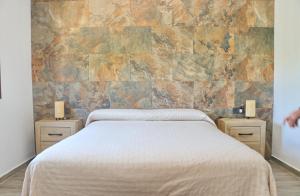ein Schlafzimmer mit einem Bett und zwei Nachttischen mit zwei Lampen in der Unterkunft Casa Marcucaña el Palmar in El Palmar