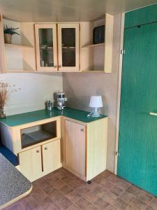 a small kitchen with a table with a lamp on it at Comfortabele familie chalets met veranda incl airco dichtbij zee! in Viareggio