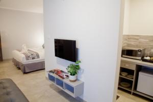 a living room with a tv on a white wall at De'Govin Apartment Lombok in Tjakranegara