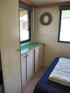 a small bedroom with a bed and a window at Comfortabele familie chalets met veranda incl airco dichtbij zee! in Viareggio +19 photos