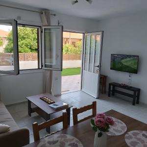 a living room with a couch and a table at Holiday Home Klimataria in Áyios Pétros