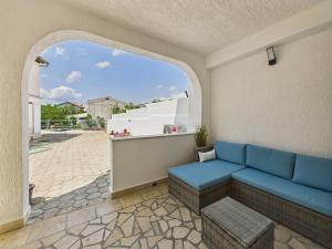 a living room with a blue couch and a window at Apartmani Jesenova in Selce