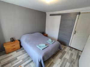 a bedroom with a bed with two towels on it at Jolie maison centre Ernée in Ernée
