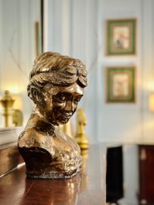 a bronze bust of a woman sitting on a table at Puddington Abbey by Art&Suites Élégant XVIIIe 80m privatif Centre ville Calme et douceur de vivre in Narbonne