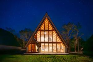 a house with a pitched roof at night at ERUSA Rusutsu in Rusutsu