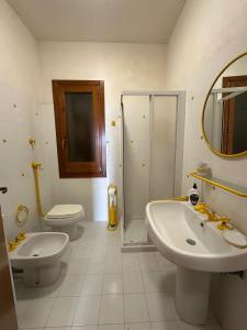 a bathroom with two sinks and a toilet and a shower at Casa Margherita in Tre Fontane