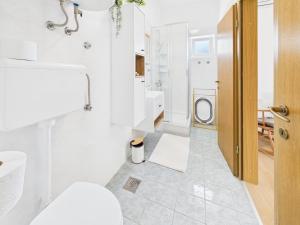 a white bathroom with a toilet and a sink at Apartmani Jesenova in Selce +20 photos