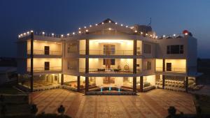 a large white building with lights on it at night at Nalluri Garden Resort in Kottapatnam