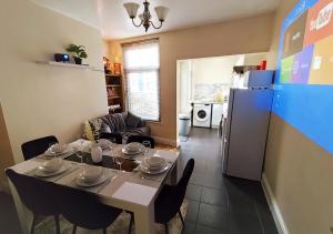 a dining room with a table and a refrigerator at Peak District Cottage in Buxton