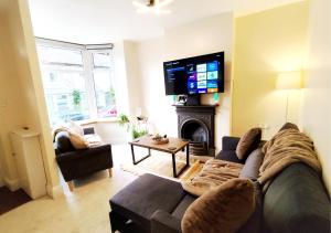 a living room with a couch and a tv at Peak District Cottage in Buxton