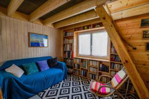 a living room with a blue couch in a library at Nitedo- Maison avec jardin et terrasse - 200m plage et forêt in Mimizan-Plage