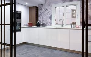 a kitchen with white cabinets and a sink at Apartamentos Elysium in Córdoba